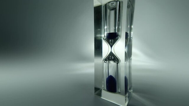 Raw time lapse macro video of modern hourglass, sandglass close-up. Sand texture, falling sand. 