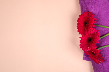 Gerbera flower on purple towel. Beauty care and spa concept