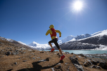 Woman trail runner cross country running in high altitude winter nature