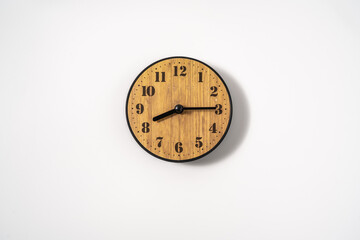 wood office wall clock with white dial on white background. wall clock on white background, top view.