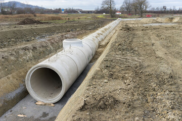 Baustelle und neu verlegte Betonrohre im Graben
