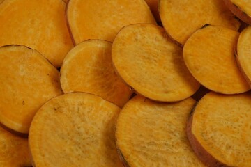 Raw sweet potato slices prepared for baking, background