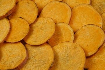 Raw sweet potato slices prepared for baking, background