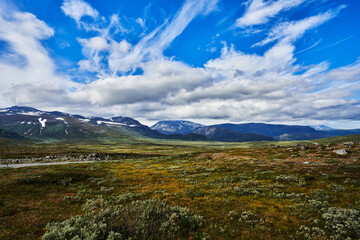 landscape of the norwegian fjell with mountains blue sky and white clouds