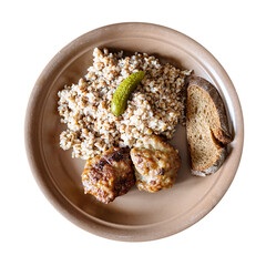 top view of served fried Kotleta (breaded minced beef steaks) with boiled buckwheat porridge on brown plate cut out on white background