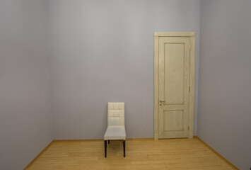 white chair in an empty room with a door