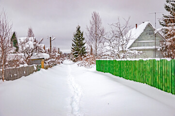 Real Russian winter, when frost and a lot of snow, in the country village, with small houses, roads through high snowdrifts