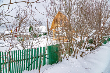 Real Russian winter, when frost and a lot of snow, in the country village, with small houses, roads through high snowdrifts