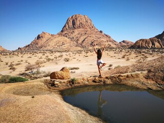 Woman practicing yoga in the beautiful rocky landscape 