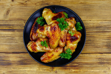 Baked chicken wings on a wooden table. Top view