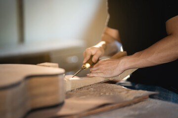 Fototapeta na wymiar craft man making guitar on wood table, capenter working concept
