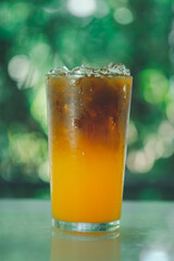 Iced black coffee mix with orange juice. Showing the texture layer of combination.