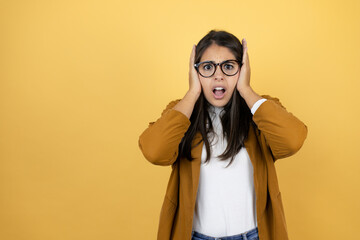 Young beautiful woman wearing a blazer over isolated yellow background suffering from headache desperate and stressed because pain and migraine with her hands on head