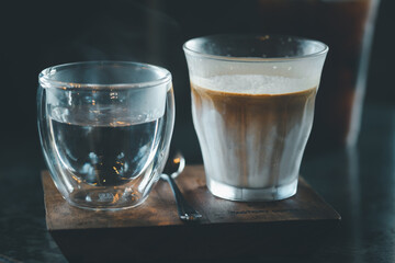 Espresso shot over cold fresh milk create gradient layer called Dirty coffee serve with warm water