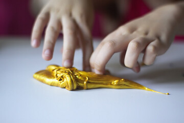 Obraz premium Child playing with a gold slime