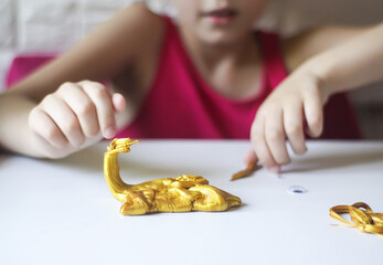 Obraz na płótnie Canvas Child playing with a gold slime