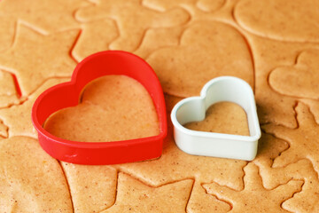 Dough for making heart shaped cookies on Valentines Day. Homemade pastry. Red and green plastic baking molds.