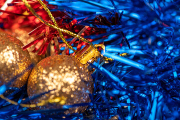 Obraz na płótnie Canvas Beautiful glass balls and colored tinsel elements of Christmas tree decoration. New year and Christmas are your favorite holidays. Close-up, selective focus.