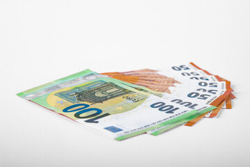 100 and 50 Euro bank notes in a row on pink background