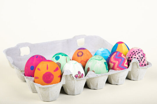 painted eggs with easter motives in an egg carton