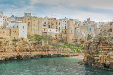 Naklejka premium Beautiful view of the buildings on the rocks and view of the sea from Polignano a mare, province of Bari in Puglia, famous tourist destination in southern Italy.