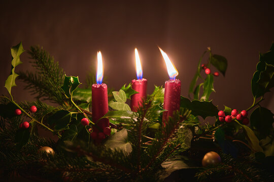 Natural Christmas table centrepiece with three red candles, ivy, holly and pine