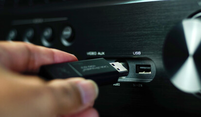 Obraz premium Man's hand plugs the Flash drive into the USB of the audio device.