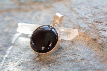 Sterling silver pendant with mineral onyx gemstone on rocky background - 401806937