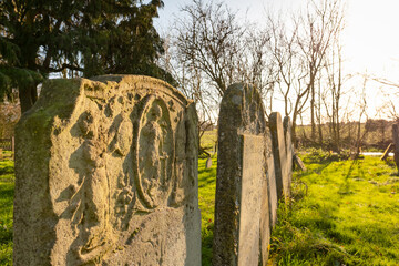 Shallow focus of very old and heavily weathered grave stones seen in a now disused cemetery and church yard.
