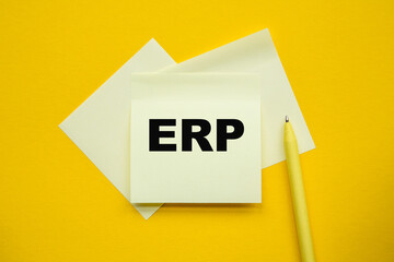 ERP - word on yellow stickers and a paper, yellow PeN on a yellow background. a bright solution for business, financial, marketing concept