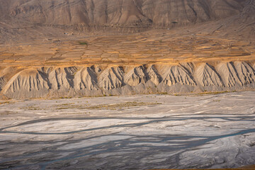 Gully erosion landscape prominent in cold desert of Spiti due to barren steep slopes & weak unconsolidated geological mud rocks. River erosion also visible on downward slopes of hills by Spiti river.