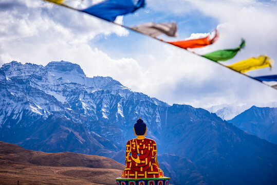 Buddha statue overlooking the valley at Langza village kaza, Spiti, Himachal Pradesh, India. Langza Village is famous for fossils of marine animals and plants which are in Tethys sea millions year ago