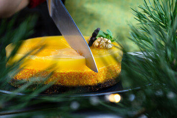 Looking up through the Christmas tree. The girl cuts Christmas raw dessert into pieces with a knife through. Vegan New Years and Christmas