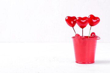 Decorative hearts in the small red bucket against the white background © kcuxen
