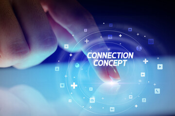 Finger touching tablet with social media icons and CONNECTI N CONCEPT