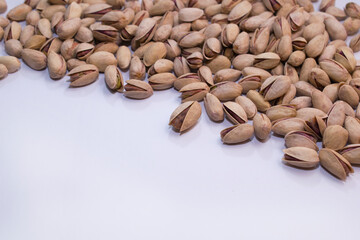 Unshelled pistachio nuts on a white background.