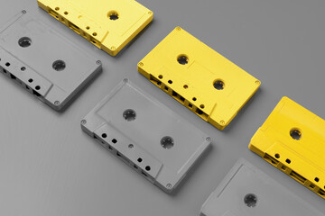 Yellow and gray audio cassettes on gray background top view
