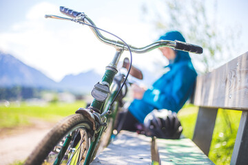 Fototapeta na wymiar Retro bike adventure: Front picture of vintage bike, girl sitting in blurry background