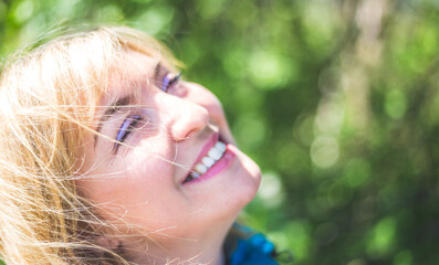 Smiling outdoors in spring. Portrait of smiling blonde girl outdoors