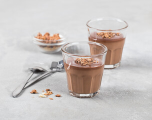 Italian dessert Panna cotta creamy hazelnut cocoa with chocolate sauce and granola in a glass on a...
