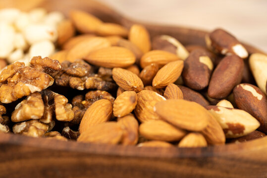 mixture of nuts in a wooden plate close-up