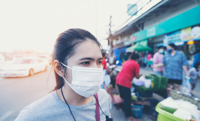 A woman wearing a mask to prevent COVID 19 lives in the community.