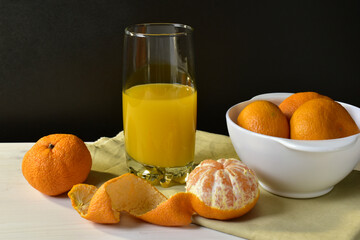 Tangerine juice and fruits on dark background