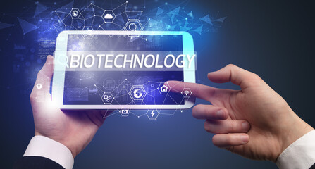 Close-up of a tablet searching BIOTECHNOLOGY inscription, hi-tech computing concept