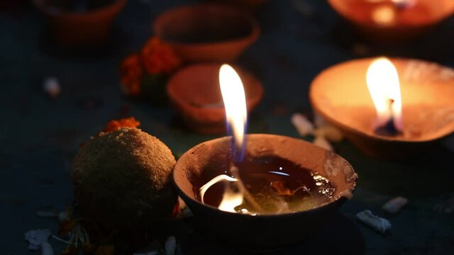 Footage of a Diya oil clay lamp illuminated during Diwali celebration with copy space. Hindu culture ritual festive celebration during corona pandemic at home. Clay diya or traditional oil lamps.