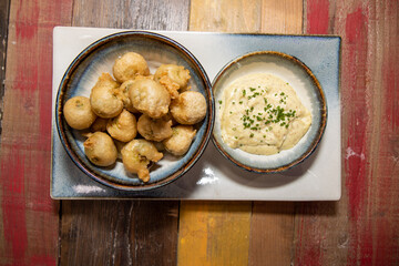 A delicious plate of cooked deep fried Brussels sprouts on a wooden kitchen background