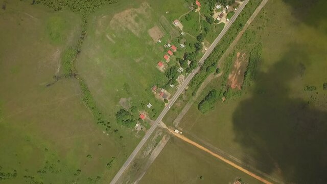 From the top view of a straight road across a green savanna