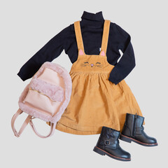 Baby and teenage set of clothes with accessories on a light background.