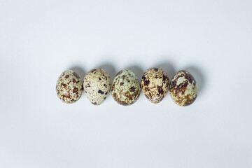 Obraz na płótnie Canvas Quail eggs on a white background. Healthy eating. Quail eggs lie in a row