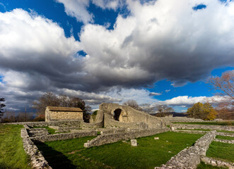 Altilia, Sepino, Molise, Italy, 05/12/2020: walls of ancient artisan shops along the Decumanum, in the background Porta Bovianum